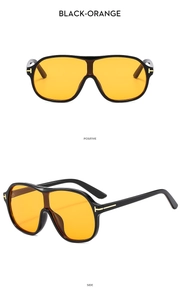 Detail view of large pilot sunglasses with black frames and orange tinted lenses