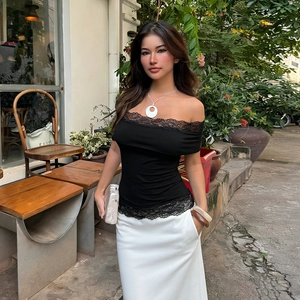 T-shirt moulant noir avec dentelle et col bardot porté dans un décor de café extérieur