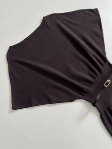 Detail view of knitted dress texture with batwing sleeves and a thin black belt