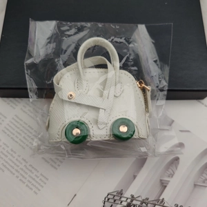 Detailed macro shot of a white shell-shaped mini coin purse charm with green wheels