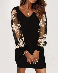 Detail of elegant V-neck dress featuring mesh sleeves with intricate floral embroidery