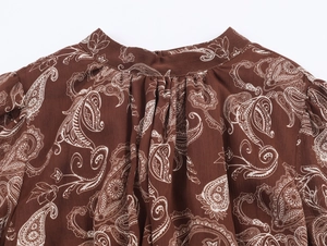 Dettaglio dello scollo dell'abito in chiffon bohémien con motivo paisley marrone e bianco