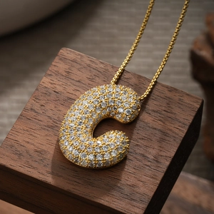 Detail of 18K gold plated letter C pendant with sparkling pave-set cubic zirconia