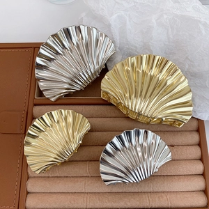 Detailed macro view of scallop shell metal hair claws in gold and silver finishes