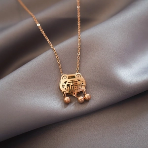 18K rose gold plated longevity lock necklace with small bells on grey silk background