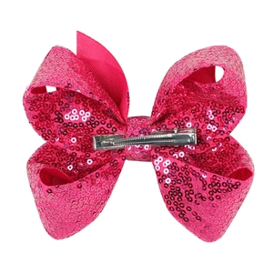 Detail view of pink sequin hair bow with durable silver metal alligator clip on back