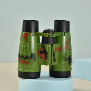 Macro shot of green camouflage binoculars for kids on a blue circular display stand