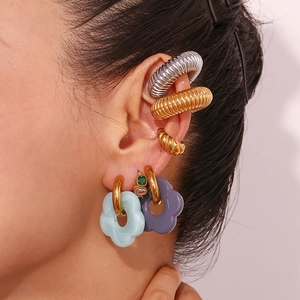 Close-up of stylish 18K gold plated hoop earrings with colorful flower charms and ear cuffs