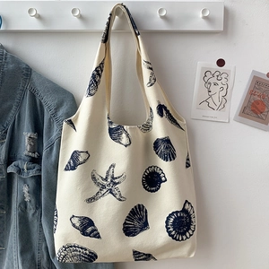 Detail of canvas tote bag with ocean shell prints and minimalist room decor hanging