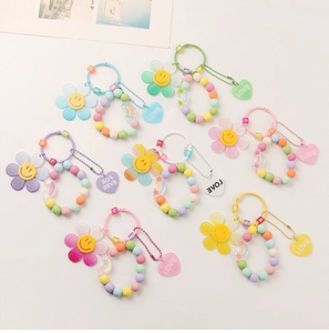 Detail of colorful DIY sunflower keychains with beaded rings and smiling flower pendants