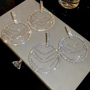 Élégantes boucles d'oreilles rondes à glands en strass or et argent sur boîte en velours