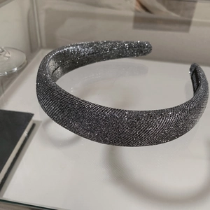 Detail of dark silver grey glitter headband showing thick padded design and sparkly texture