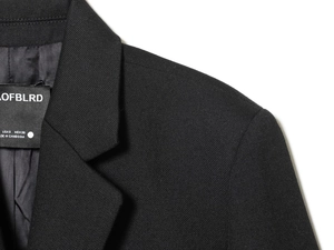 Detail view of black blazer collar showing inner woven texture and brand size tag