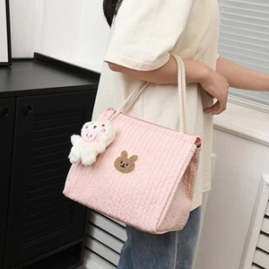 Pink quilted denim tote bag detail featuring brown bear embroidery and cream rope strap