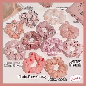 Detailed set of eleven assorted organza and satin scrunchies in pastel pink and peach tones