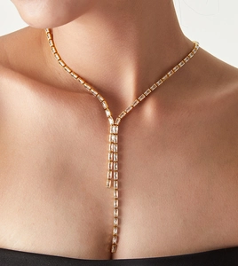 Détail d'un collier en Y doré avec zircons rectangulaires sur le cou du mannequin