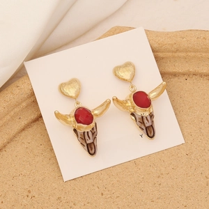 Detailed view of bull head stud earring with red gemstone and vintage gold texture