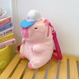 Cute pink plush capybara backpack with a blue baseball cap on a wooden bench