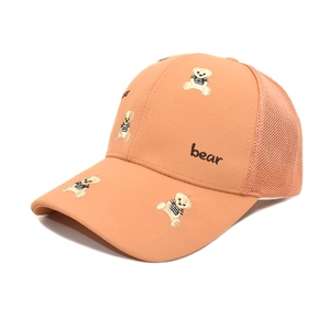 Gros plan sur la broderie d'ours et la texture en maille respirante de la casquette abricot
