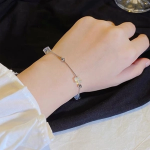 Close-up of minimalist silver chain bracelet with square crystal beads on a female wrist