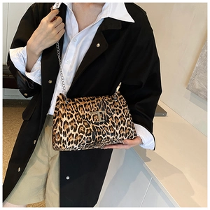 Detail shot of leopard print shoulder bag featuring a silver metal T buckle and chain strap