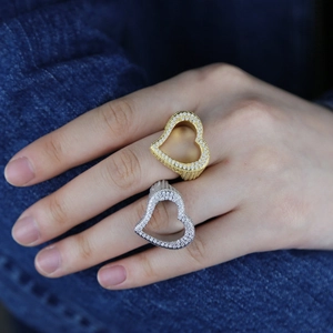 Detail of hip hop hollow heart ring in gold and silver finish with zircon micro-paving