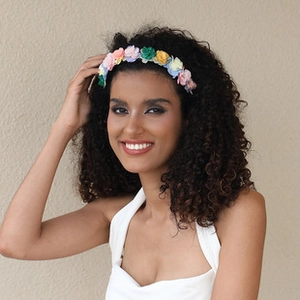 Detail of colorful handmade fabric flower headband with fringe and floral accents