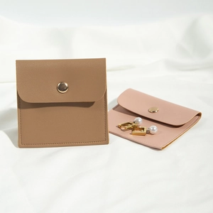Detail of khaki and pink PU leather jewelry pouches with golden metal snap fasteners