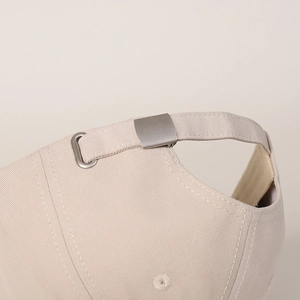 Detail of adjustable metal buckle and beige twill cotton strap on the baseball cap