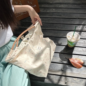 Detail of canvas tote bag featuring cute bear print and orange braided rope handles
