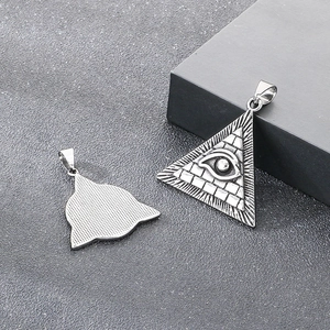 Macro detail of All-Seeing Eye pendant showing silver geometric design and textured back