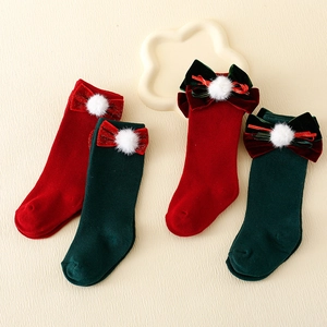 Red and green Christmas socks with velvet bows and white pompoms for kids