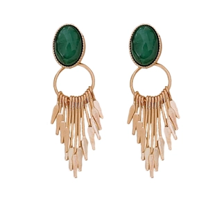 Vintage gold tassel earrings with oval green gemstone and dangling chains on white background