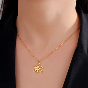Golden snowflake pendant necklace on model with black suit for winter jewelry fashion