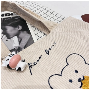 Detail of corduroy tote bag featuring Bear Bear embroidery and cute cartoon calf pendant