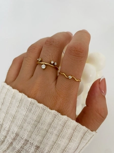 Detail of 18K gold plated minimalist rings with cubic zirconia on female model hand