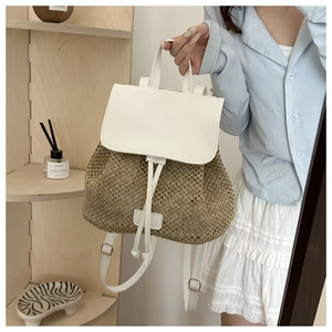 Detail of woven straw backpack with white faux leather drawstrings and mesh texture