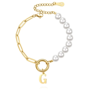 Detailed macro of paperclip chain and white pearl bracelet with capital letter G pendant