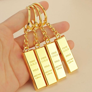 Hand holding four fine gold bar keychains with 999.9 engraving in a 1.00 oz design