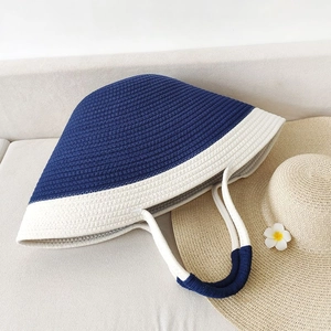 Blue and white woven cotton rope beach tote bag placed on a cozy sofa for summer vacation