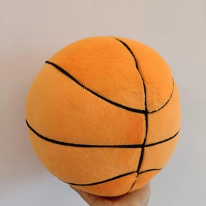Close-up of a soft plush basketball pillow showing the orange velvet texture and stitching
