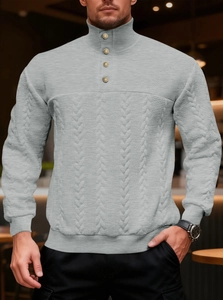 Close-up of vintage grey knit sweater featuring textured patterns and metallic button details