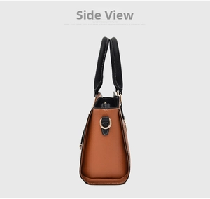 Detail view of brown lychee grain leather handbag with black handles and gold D-rings