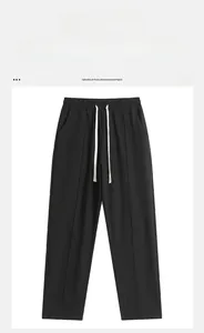 Detail of black wide-leg sweatpants featuring elastic waistband and contrast drawstrings