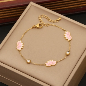 Golden bracelet featuring pink lotus charms and white zircon stones on beige jewelry box