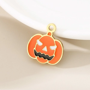 Detail shot of a Halloween pumpkin charm in orange enamel with gold-tone hardware finish