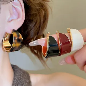 Boucles d'oreilles créoles C en résine plaquée or 18 carats avec design géométrique