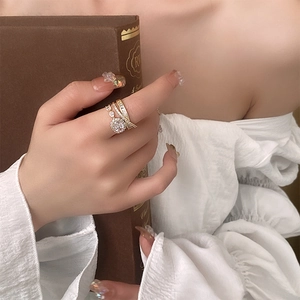 Macro detail of multilayer gold ring with round central zircon and pavé diamond band