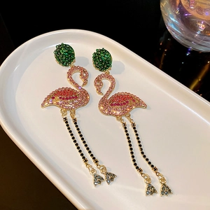 Detailed view of luxury flamingo earrings with pink rhinestones and gold tassels