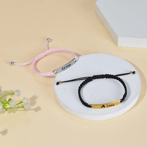 Detailed view of woven bracelets with custom engraved metal plates in gold and silver